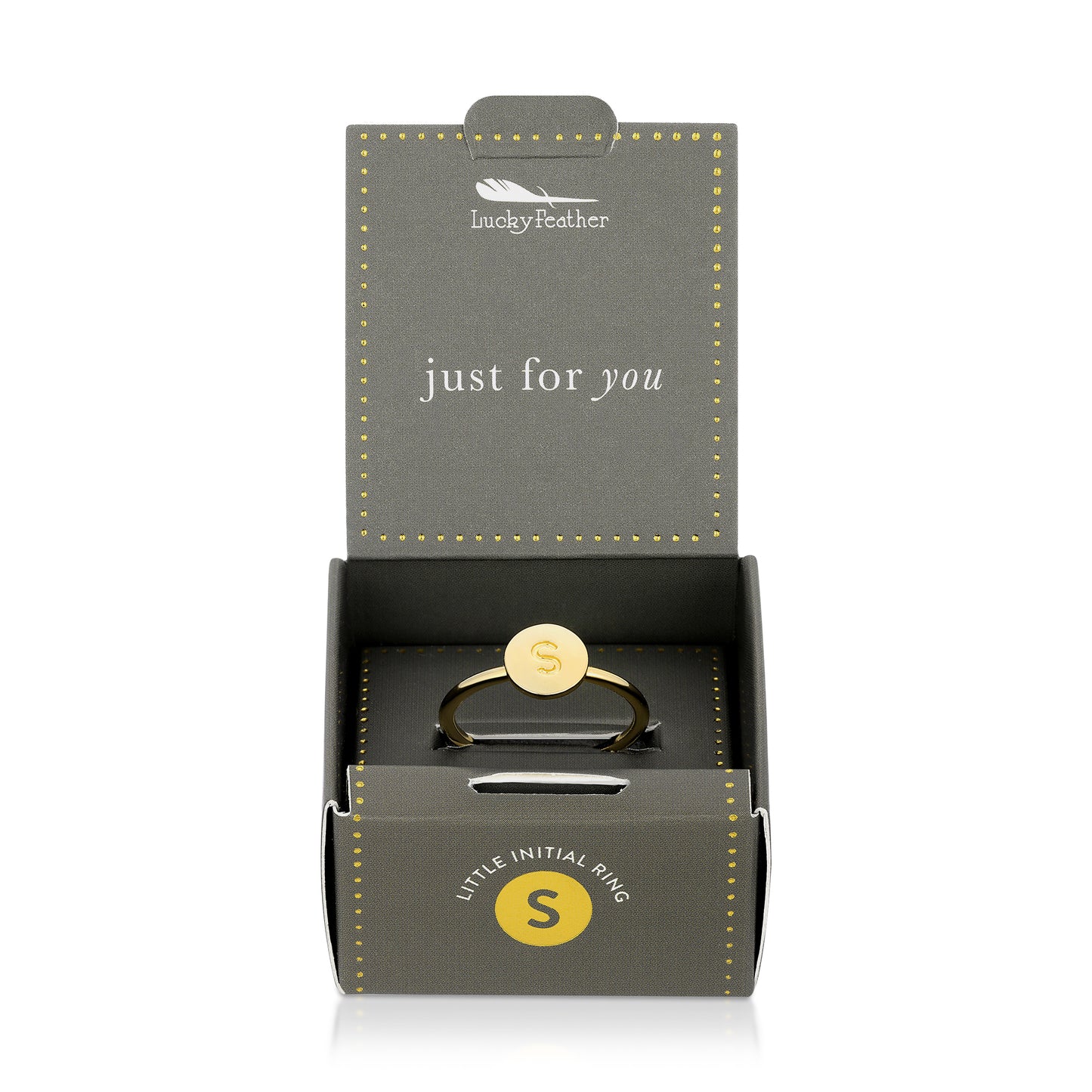 A "Lucky Feather" ring box is open, displaying a gold ring with the letter "S" on it.