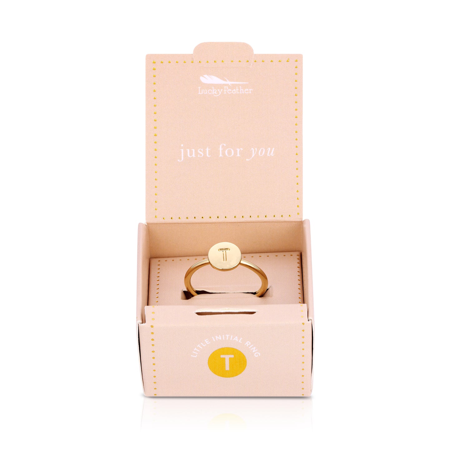 A gold initial ring with the letter "T" is displayed in an open, peach-colored "Lucky Feather" gift box.