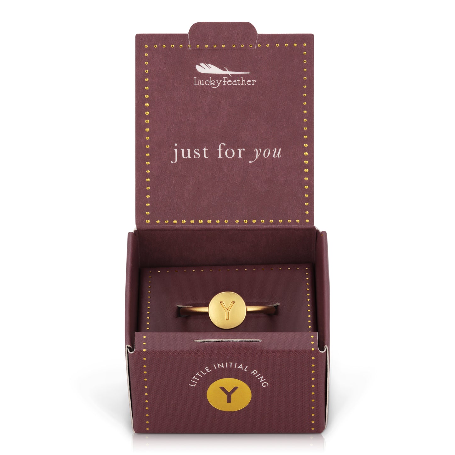 A gold ring with the letter "Y" on a round face is displayed in an open, maroon "Lucky Feather" gift box.