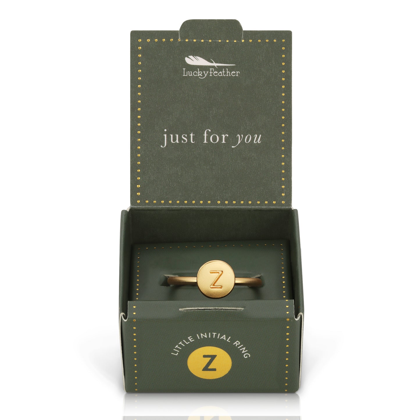 A gold ring with the letter "Z" inside an open, decorated green box.