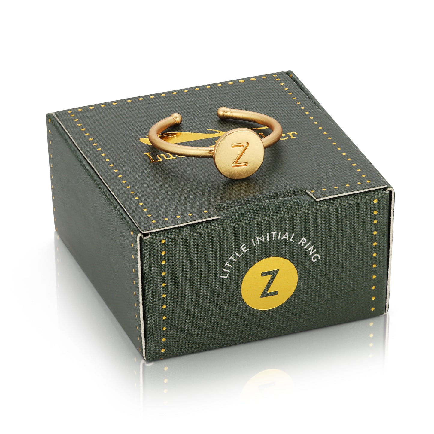 A gold-colored ring with the letter "Z" sits atop a small, green and gold gift box.