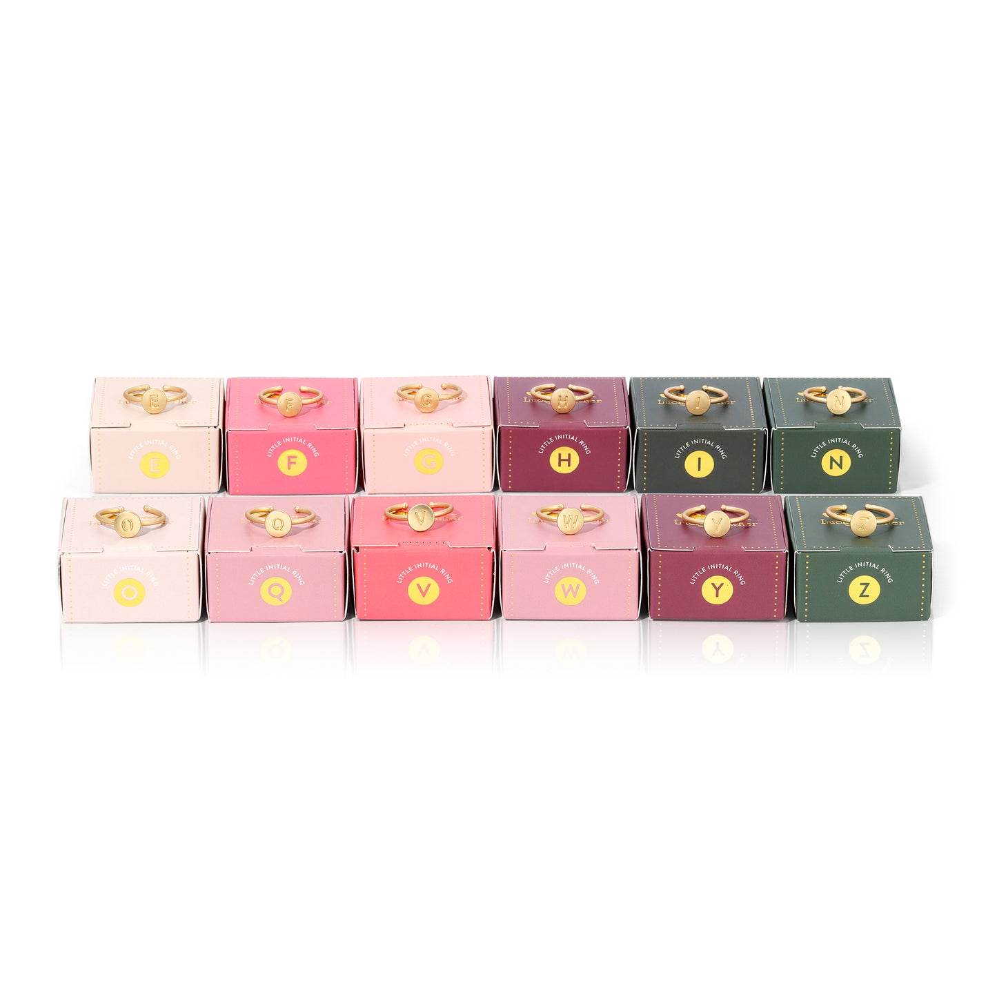 A display of rings with different initials atop matching boxes in various colors.