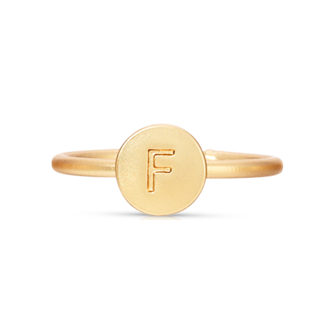 A gold ring with a circular face imprinted with the letter F.