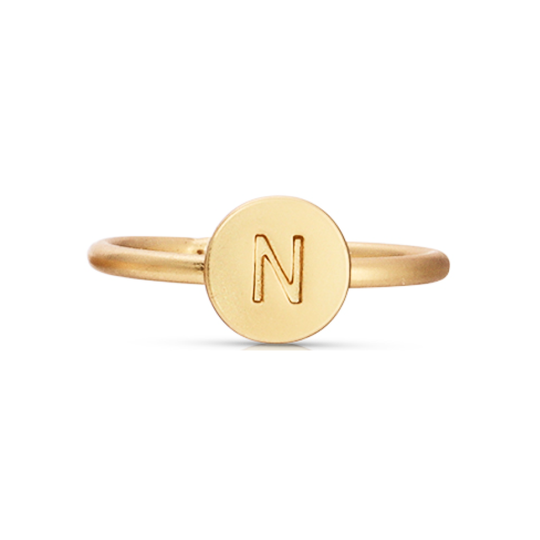 A gold-colored ring features a circular face with the letter N on it.