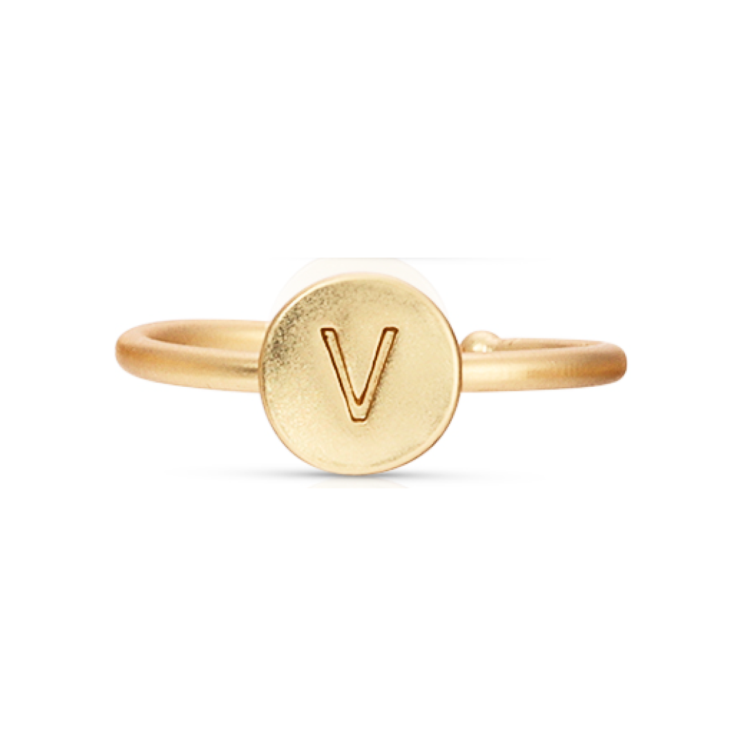A gold-colored ring features a circular face with the letter "V" engraved on it.