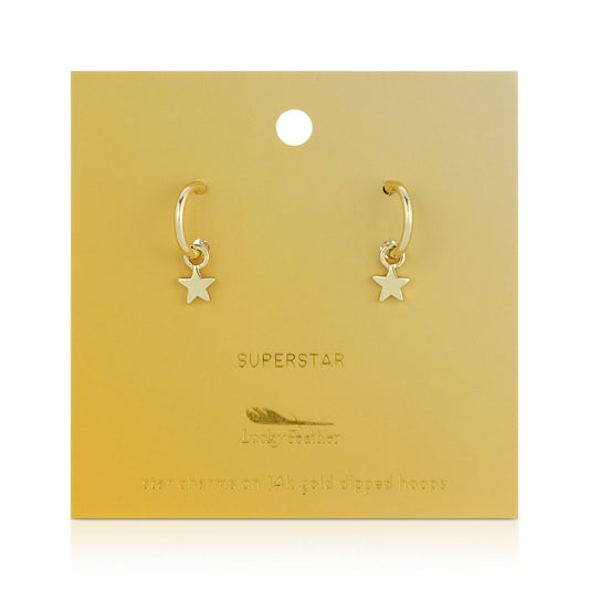 Two gold hoop earrings with star charms on a gold display card.