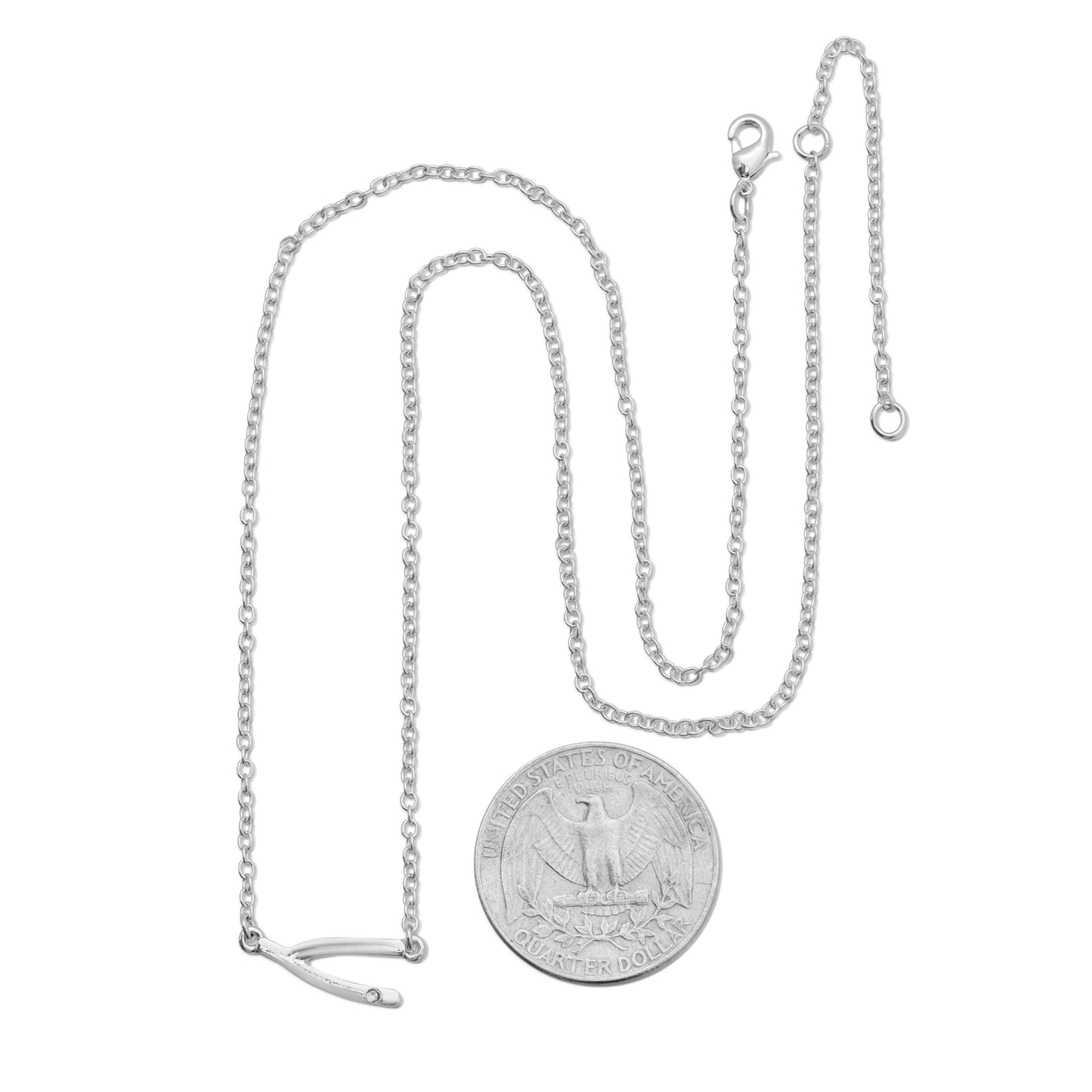 A silver wishbone pendant necklace is displayed with a U.S. quarter for scale.