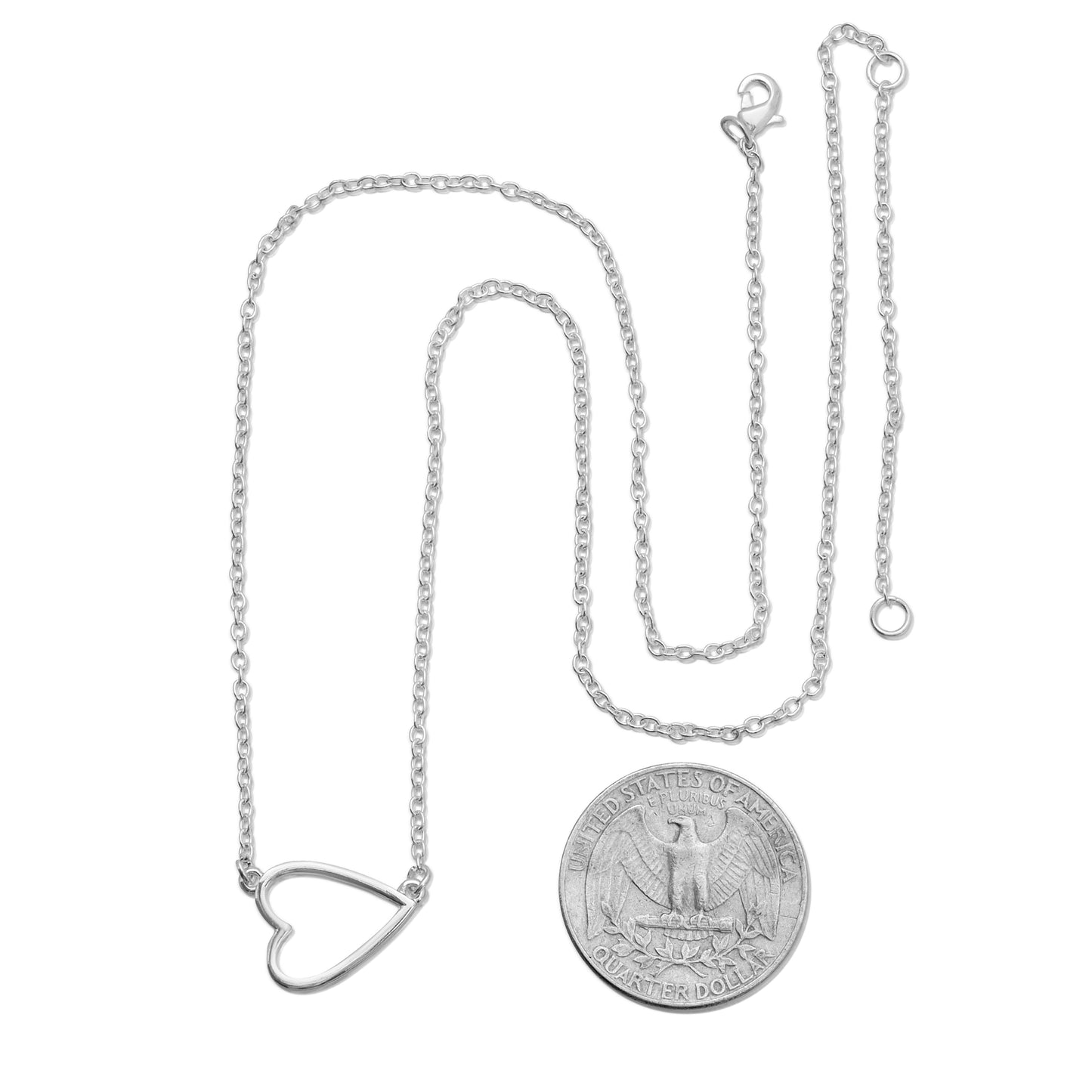A silver heart pendant necklace next to a US quarter.