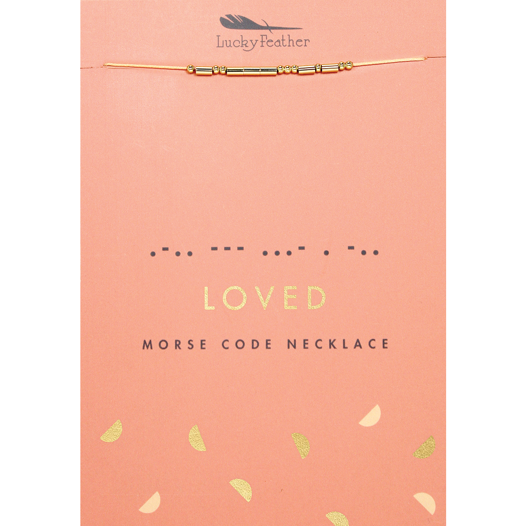 A 'Lucky Feather' Morse code necklace spelling 'loved' on a pink card.