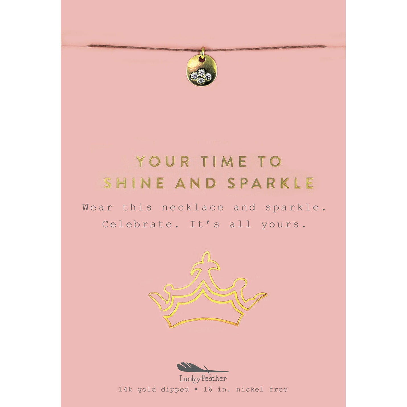A necklace with a gold charm is on a pink display card with a crown graphic.
