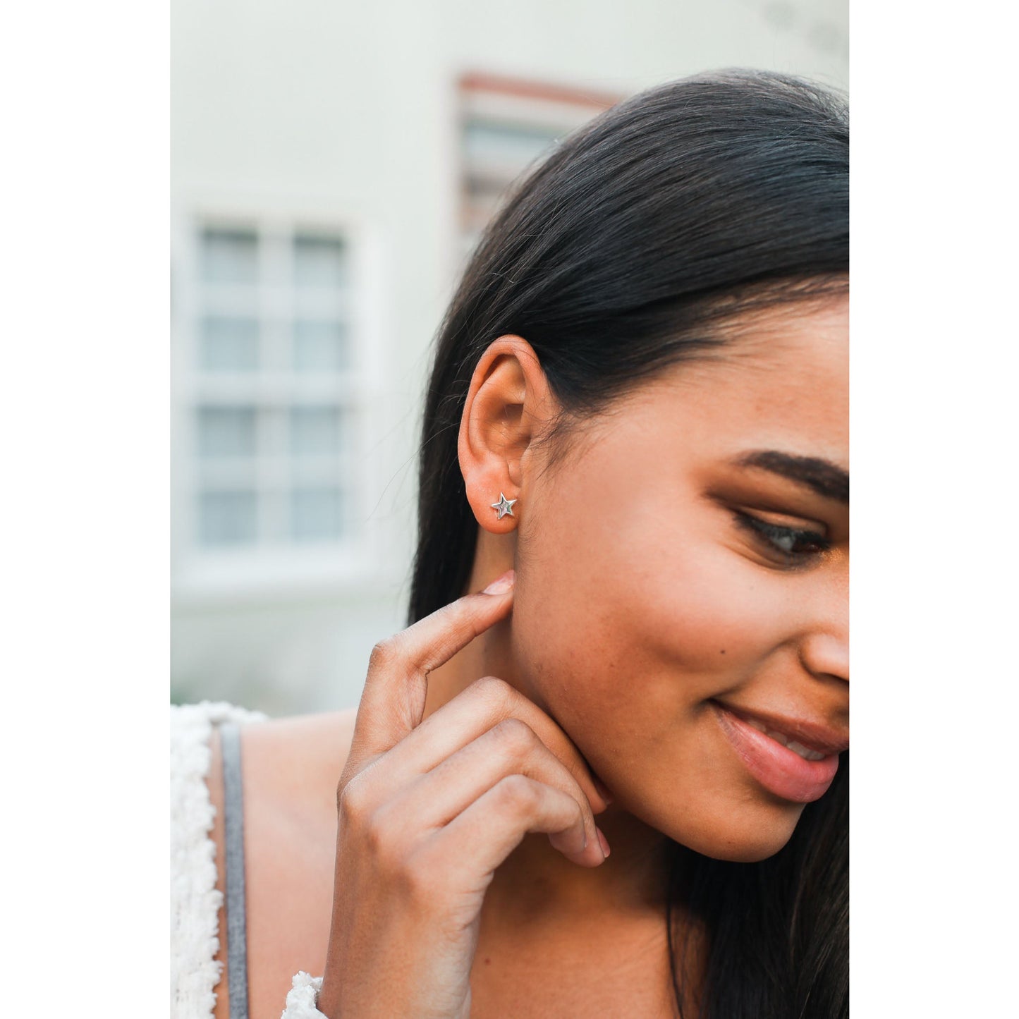 Close-up of a smiling woman with a star earring.