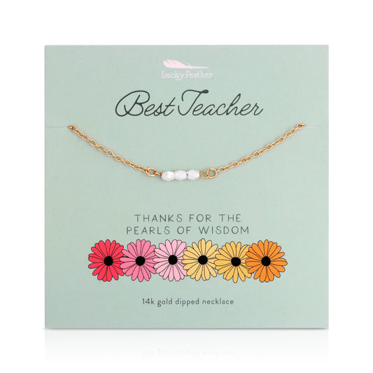Gold-toned necklace with three white beads on a card that reads 'Best Teacher' with flowers at the bottom.