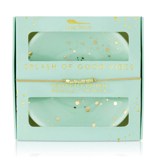 A 'Lucky Feather' branded gift box with a bracelet and two trinket dishes in a mint color with gold accents.