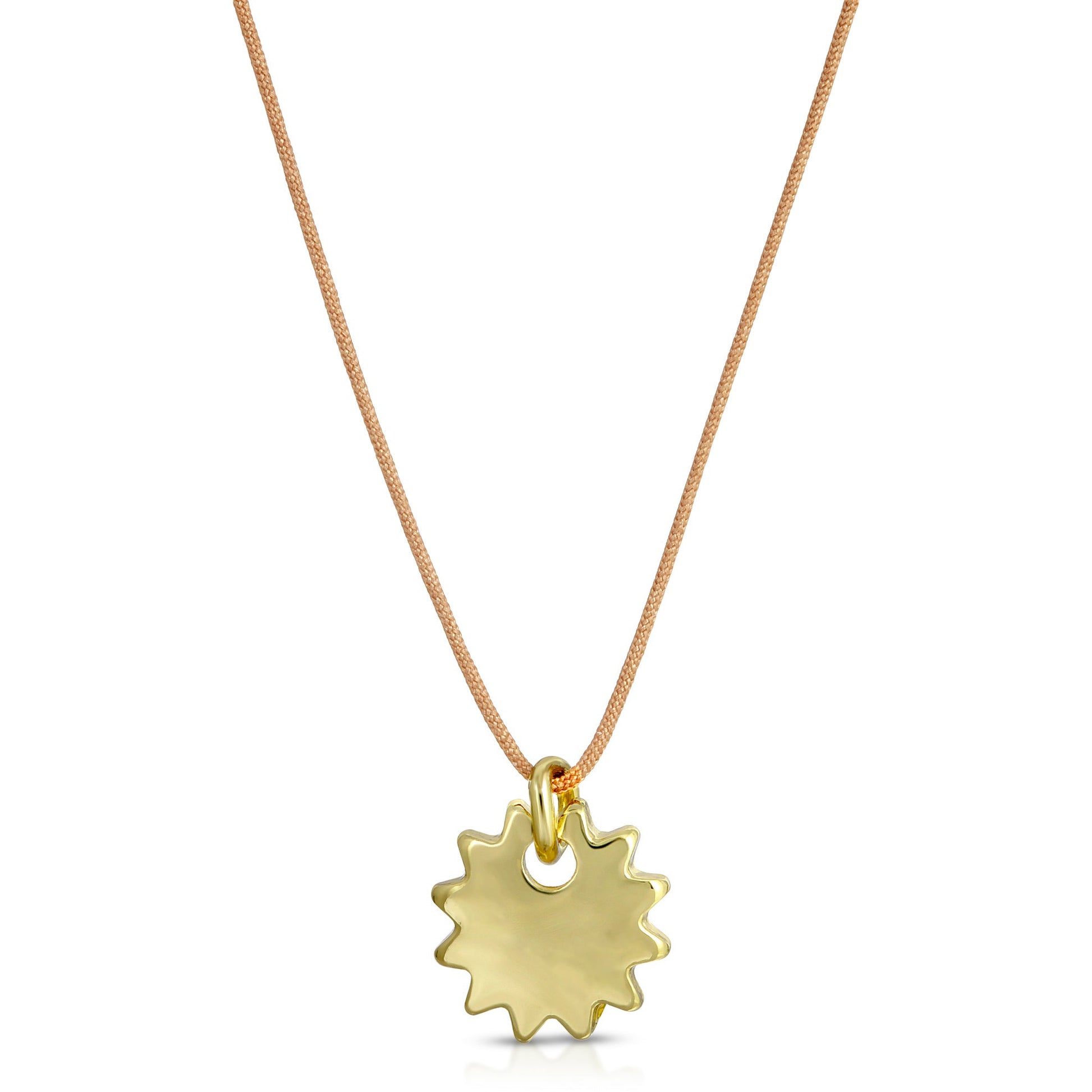 A gold sunburst pendant hangs from a tan cord necklace.