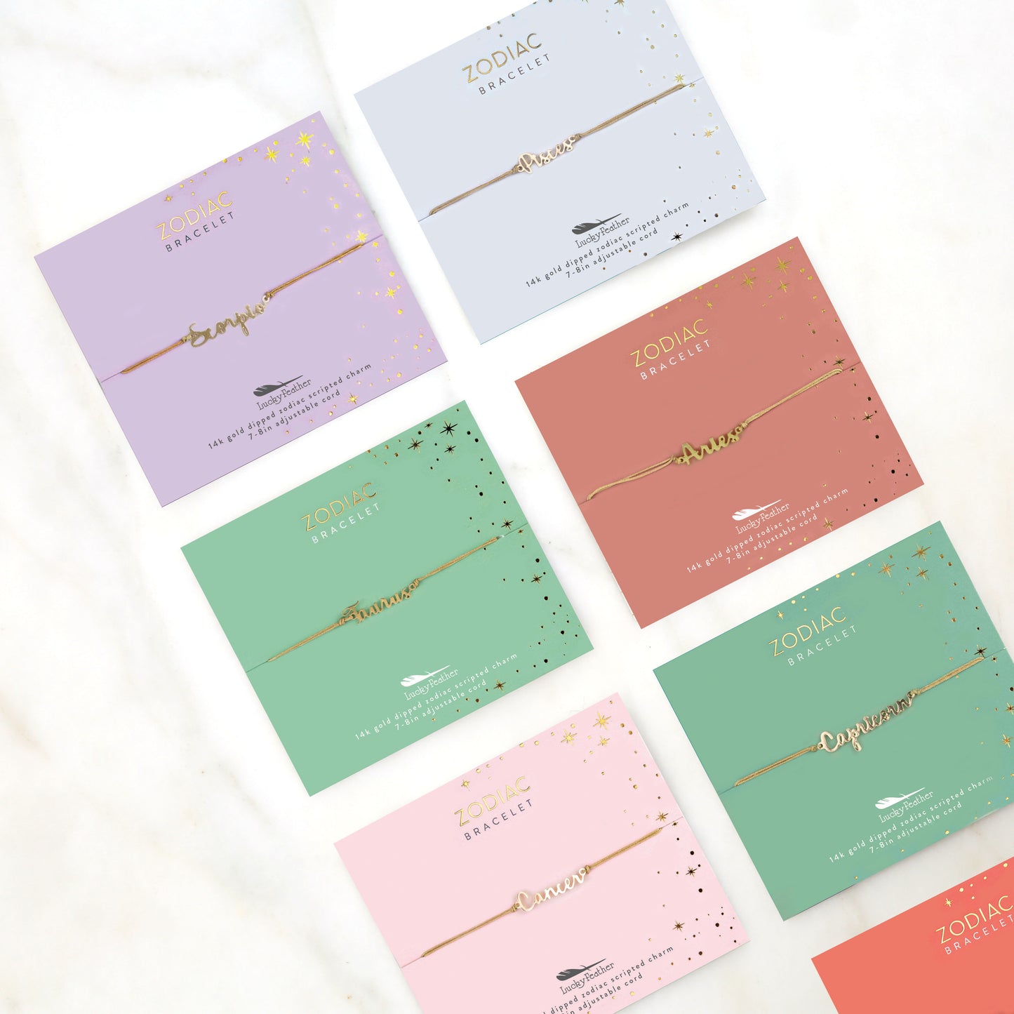 Several packaged zodiac bracelets with star sign charms displayed on a white surface.